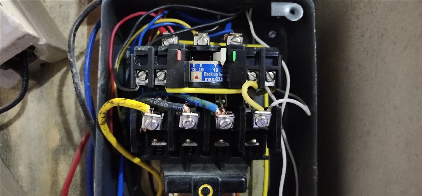 Close-up of a bore motor starter panel contactor and overload relay installed in Kamareddy