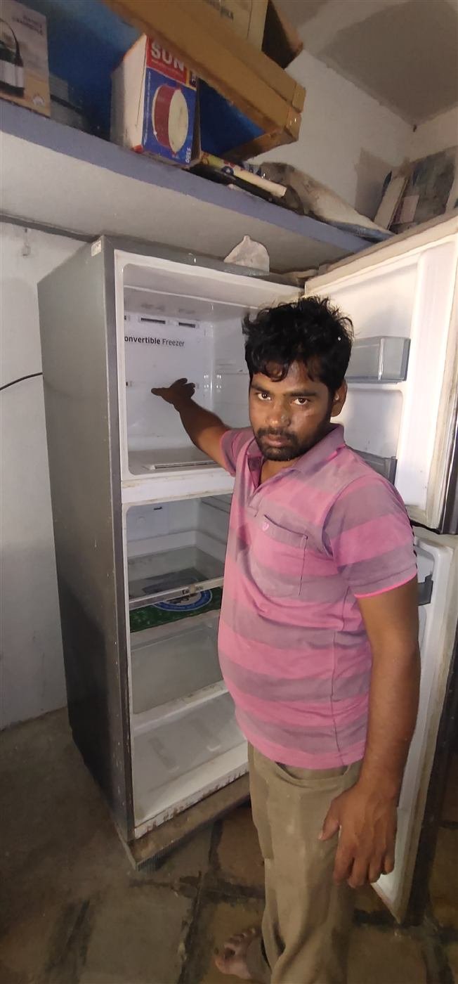 AN Repair Services technician showing a customer the inside of a repaired refrigerator freezer compartment in Kamareddy